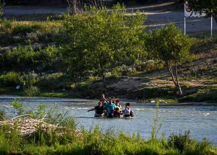 یک خانواده پناهجوی ونزوئلایی در حال عبور از رود مرزی "ریو گرانده"
