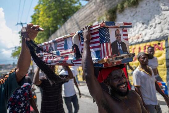معترضان ضد دولتی در هائیتی تابوت نمادین نخست وزیر این کشور را با پرچم های آمریکا و کانادا دفن کردند.  / رویترز