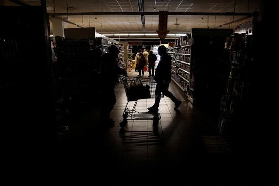 مردم در هنگام قطع برق در سراسر کشور از یک سوپرمارکت در خارکف اوکراین خرید می کنند.