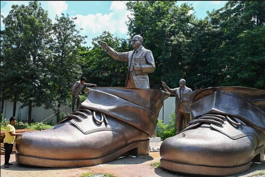 کارگران روی کفش های مجسمه 38 متری یک اصلاح طلب اجتماعی هندی کار می کنند