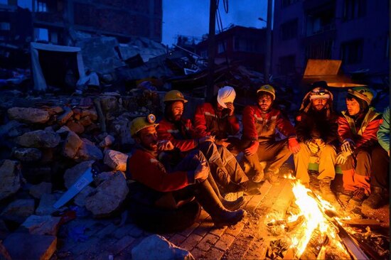 یک تیم امداد و نجات در حال گرم شدن در شهر زلزله زده هاتای ترکیه