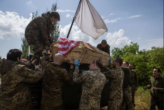 سربازان اوکراینی تابوت یک سرباز کشته شده ارتش آمریکا در جبهه باخموت را حمل می کنند