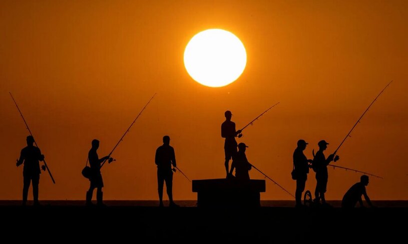 دیدنی های امروز؛ از گرمای بی سابقه تابستانی تا شعار نویسی معترضان فرانسوی ماهیگیری در غروب آفتاب