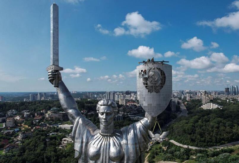 کارگران اوکراینی در حال برداشتن نشان "داس و چکش"