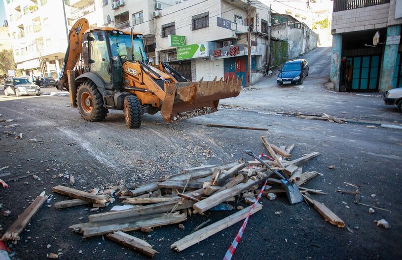 بولدوزر فلسطینی در حال جمع آوری مخروبه های حمله هوایی اسراییل