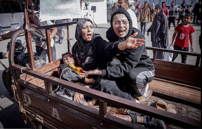 مادر فلسطینی در حال انتقال پسر زخمی اش به بیمارستانی در نوار غزه