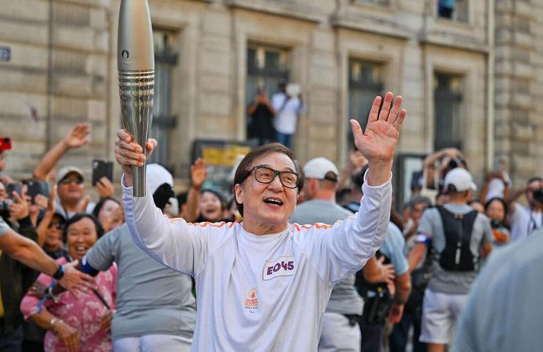 جکی جان در حال حمل مشعل افتتاحیه مسابقات پارالمپیک