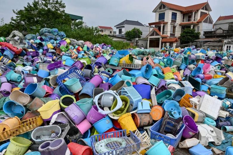 انبوه زباله های پلاستیکی در یک سایت بازیافت در کنار یک منطقه مسکونی