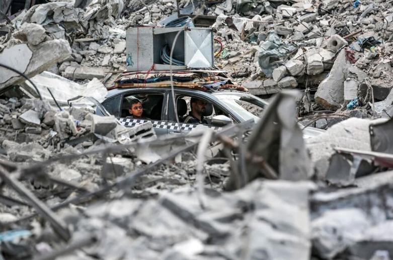 عبور یک خودرو از ویرانه های جنگ در شهر خان یونس