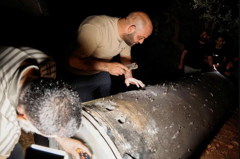 فلسطینی ها در حال بررسی پوکه موشک ایرانی 