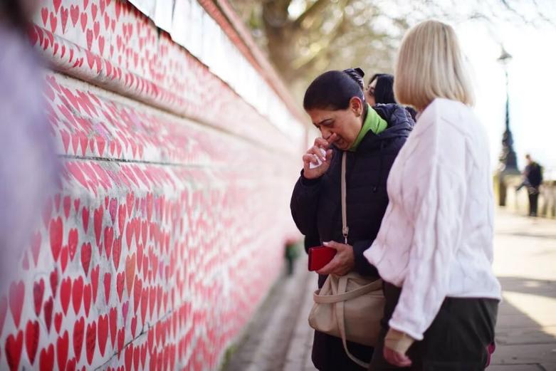 شرکت کنندگان در مقابل دیوار یادبود ملی "کووید"