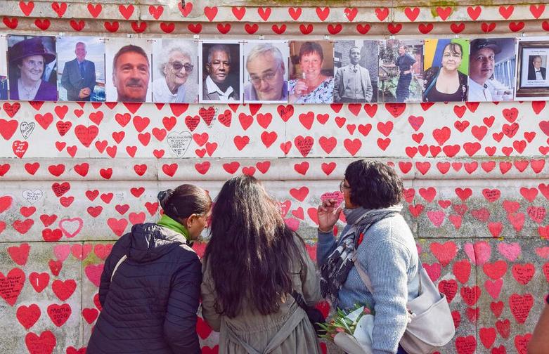 شرکت کنندگان در مقابل دیوار یادبود ملی "کووید"