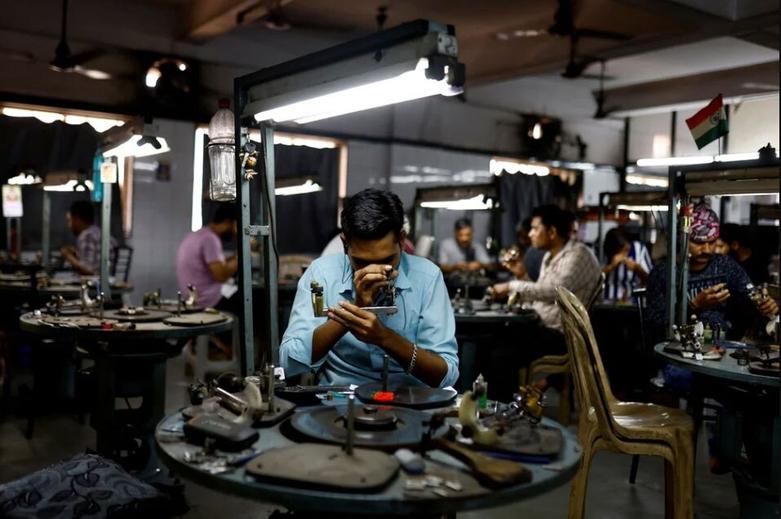 صنعتگران در یک واحد فرآوری الماس در شهر "سورات" هند روی الماس کار می کنند