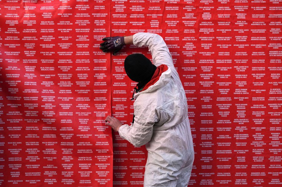 دیدنی های امروز؛ از بوقلمون های روز شکرگزاری در کاخ سفید تا دردسر باران برای مردم غزه مردی در حال نصب پوستری حاوی نام امدادگران کشته شده در غزه