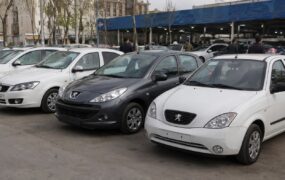 خودروی داخلی در نمایشگاه در کنار یک خانواده در حال بررسی قیمت