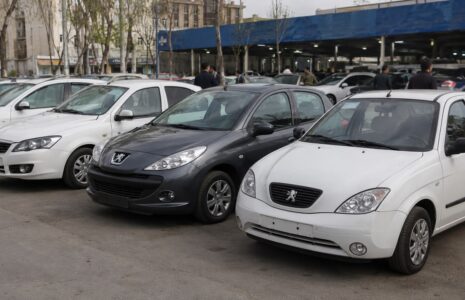خودروی داخلی در نمایشگاه در کنار یک خانواده در حال بررسی قیمت