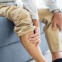 Old,Man,Suffering,From,Knee,Pain,Sitting,Sofa,In,The